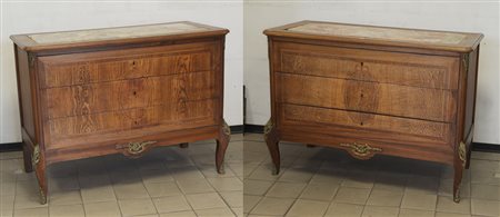 Coppia di cassettoni a tre cassetti con fronte decorato a motivi vegetali,...