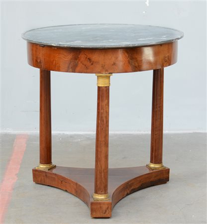 Tavolino Impero tondo in noce con tre gambe a colonne riunite da crociera,...