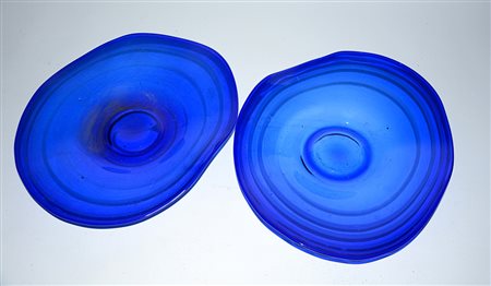 Lotto composto da due centrotavola a bordo sagomato in vetro blu decorato a...