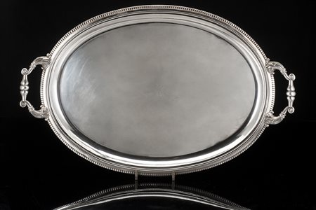 Vassoio in metallo a due manici di forma ovale con fondo liscio inciso da...