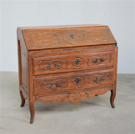 Antica ribalta in noce intagliata a cartelle polilobate. Fronte mosso a tre...