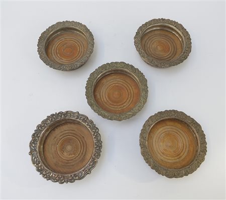 Lotto di cinque sottobottiglie in rame argentato, decorati in rilievo (d cm...