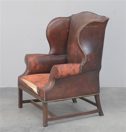 Poltrona a orecchioni rivestita in pelle borchiata, Inghilterra secolo XX...