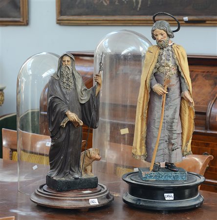 Lotto composto da due teche contenenti sculture in legno laccato raffiguranti...