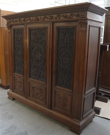 Armadio in legno intagliato a motivi rinascimentali, tre ante a vetri...