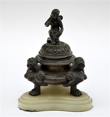 Calamaio in bronzo con coperchio decorato a figura alata e vasca sorretta da...