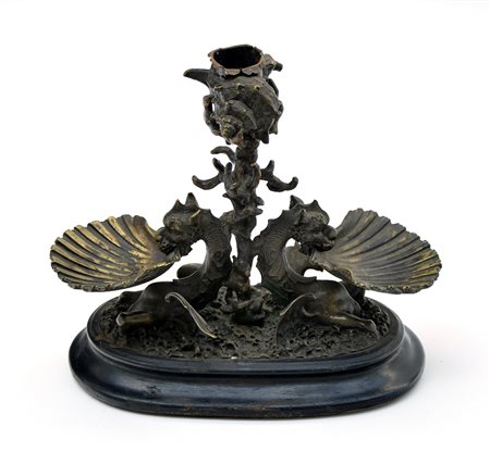 Saliera in bronzo con vasche a forma di valve di conchiglia sorretta a figure...