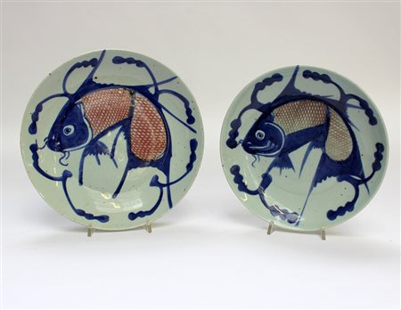 Due piatti a decoro bianco, blu e rosso raffiguranti carpe, manifattura sud...