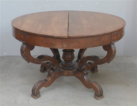 Tavolo in noce di forma tonda con montanti d piedi sagomati e intagliati a...