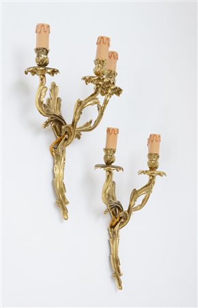 Coppia di appliques a tre fiamme in bronzo dorato a decoro fogliaceo (h cm...