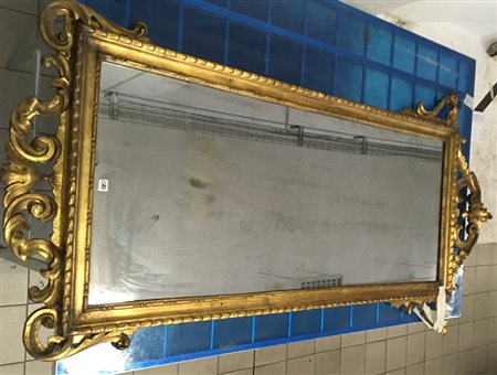 Specchiera con cornice in legno intagliato e dorato a volute con cimasa...