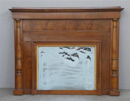 Caminiera in noce con montanti a mezza colonna scanalata e cornice interna...