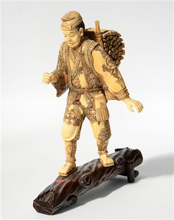 Okimono raffigurante boscaiolo con fascina sulle spalle. Base in legno con...