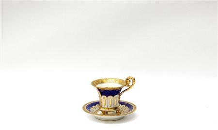 Manifattura del secolo XIX, tazza con piattino in porcellana a fondo blu con...