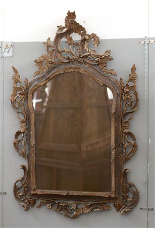 Specchiera con cornice in legno intagliato decorato con volute di gusto...