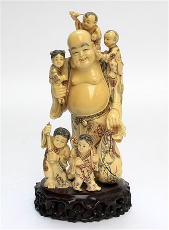 Scultura in avorio raffigurante Hotei con fanciulli e sacco, base in legno...