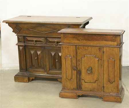 Lotto di due mobiletti in legno a tinta scura con decoro a bugne con piani...