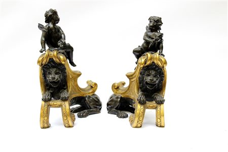 Coppia di alari in bronzo brunito e dorato raffiguranti leoni e putti alati