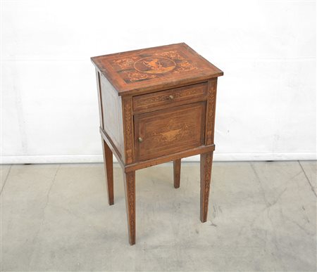 Comodino ad un'anta e un cassetto intarsiato a volute fogliate e a putto...