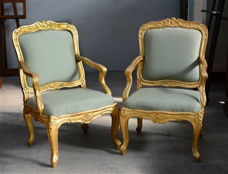 Coppia di poltrone in stile settecentesco in legno intagliato e dorato a...