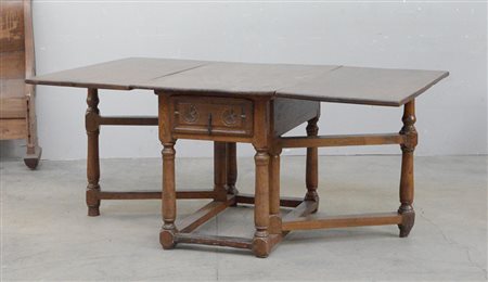 Antico tavolo ad alette "Spagnolo" a due cassetti intagliati a rosoni, otto...