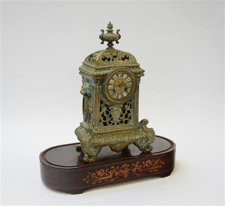 Pendola da tavolo in bronzo a decoro fogliaceo con cassa traforata ed anse a...