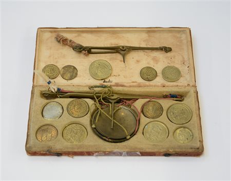 Piccola bilancia da viaggio con alcuni pesi in custodia in pelle impressa,...