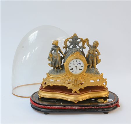 Pendola da camino in metallo dorato con cassa sormontata da figure di...