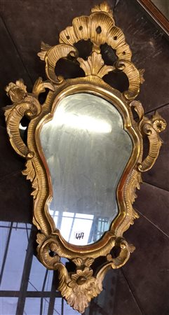 Antica specchierina in legno intagliato e dorato di forma sagomata (cm 41x70)...