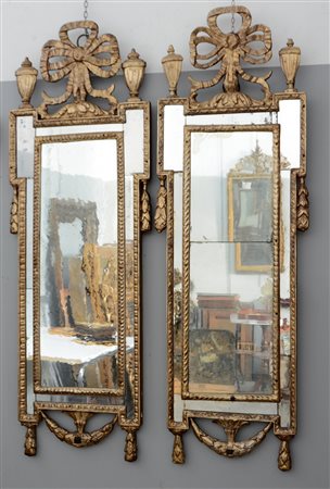 Coppia di specchiere in legno intagliato e dorato a mecca. Cimasa decorata...