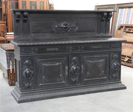Credenza con alzata in legno ebanizzato e intagliato a cartigli, due cassetti...