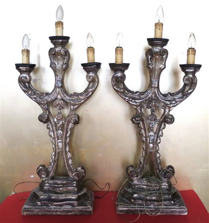 CANDELABRI, Coppia candelabri lignei a tre fiamme argentati poggianti su base...