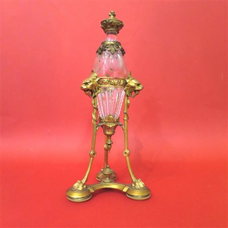 BOTTIGLIA, Bottiglia in cristallo sostenuta da tripode in bronzo dorato - h...