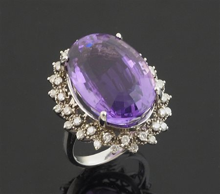 Grande anello in oro bianco con ametista centrale di forma ovale contornata...