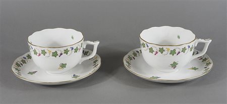 Herend: coppia di grandi tazze in porcellana con decori floreali e due piatti.