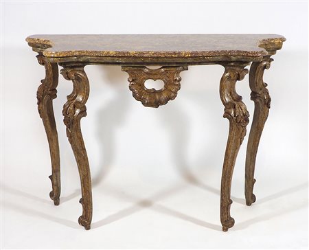 Consolle in legno su alte gambe mosse scolpite, piano sagomato in marmo....