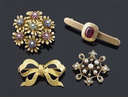 Lotto composto da 3 spille in oro 18 kt una a forma di fiocco, e due floreali...