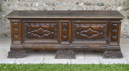 Cassapanca in legno di noce con fronte finemente intagliato, piedi a mensola...