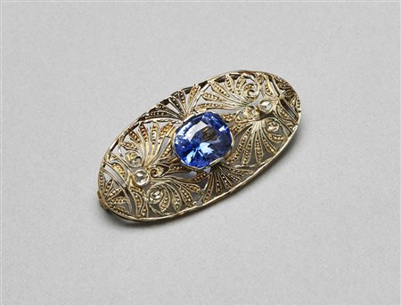 Spilla in oro bianco, diamanti e zaffiro centrale. . . . [Nessun Autore] . . .