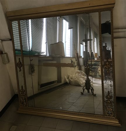 Caminiera in legno dorato decorata con inserti in legno intagliato a volute...