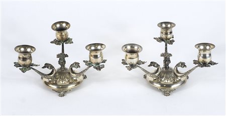 Paio di piccoli candelabri in argento a 3 fiamme. H. cm. 9. Gr. 430.