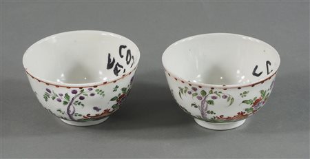 Coppia di tazzine in porcellana con decori policromi a motivi floreali....