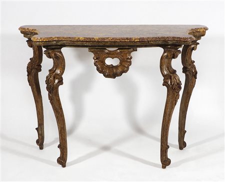 Consolle in legno su alte gambe mosse scolpite, piano sagomato in marmo....
