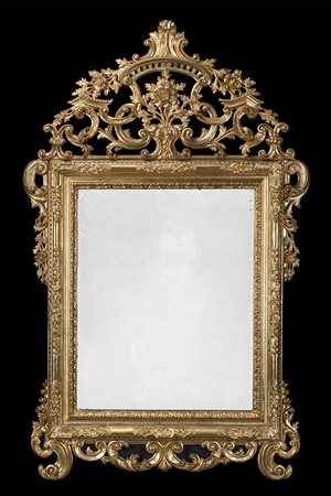 Specchiera in legno intagliato e dorato, cimasa e fregi traforati e scolpiti...
