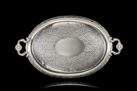 Vassoio biansato in argento con fascia e cavetto incisi a volute e motivi...