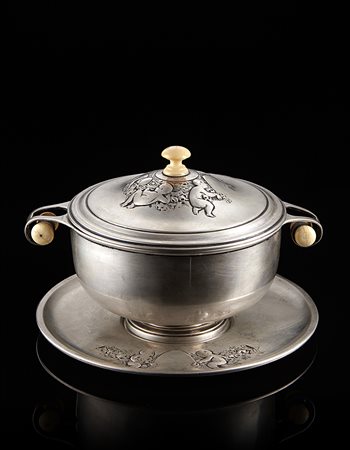 Scatola biansata con piattino in argento a corpo liscio. Coperchio sbalzato e...