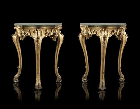 Coppia di piccole consolles in legno intagliato e dorato a volute fogliate e...