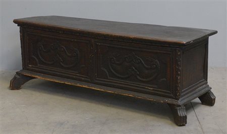 Cassapanca in legno con specchiature incorniciate e decori intagliati. (cm...