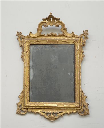 Specchiera con cornice in legno intagliato e dorato, cimasa ed angoli...