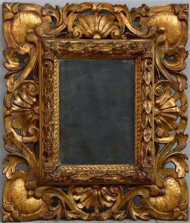Specchiera con cornice in legno intagliato e dorato decorata da foglie e...
